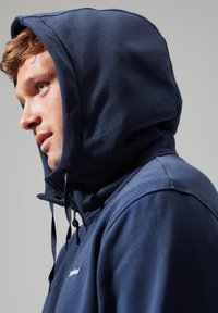 Navy fleece hoodie with a high collar, adjustable drawstrings, and a logo on the chest. Soft texture with a fitted design.