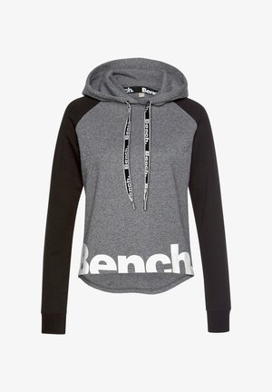 Gray and black hooded sweatshirt with long sleeves, a curved hem, and a large white logo. Features a drawstring with branded accents.