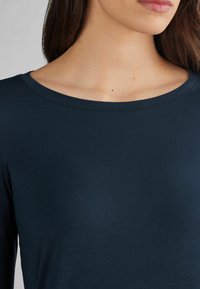 Langärmliges Oberteil in Dunkelblau mit rundem Ausschnitt. Aus weichem Stoff gefertigt, mit glatter Textur und ohne sichtbare Muster oder Akzente.