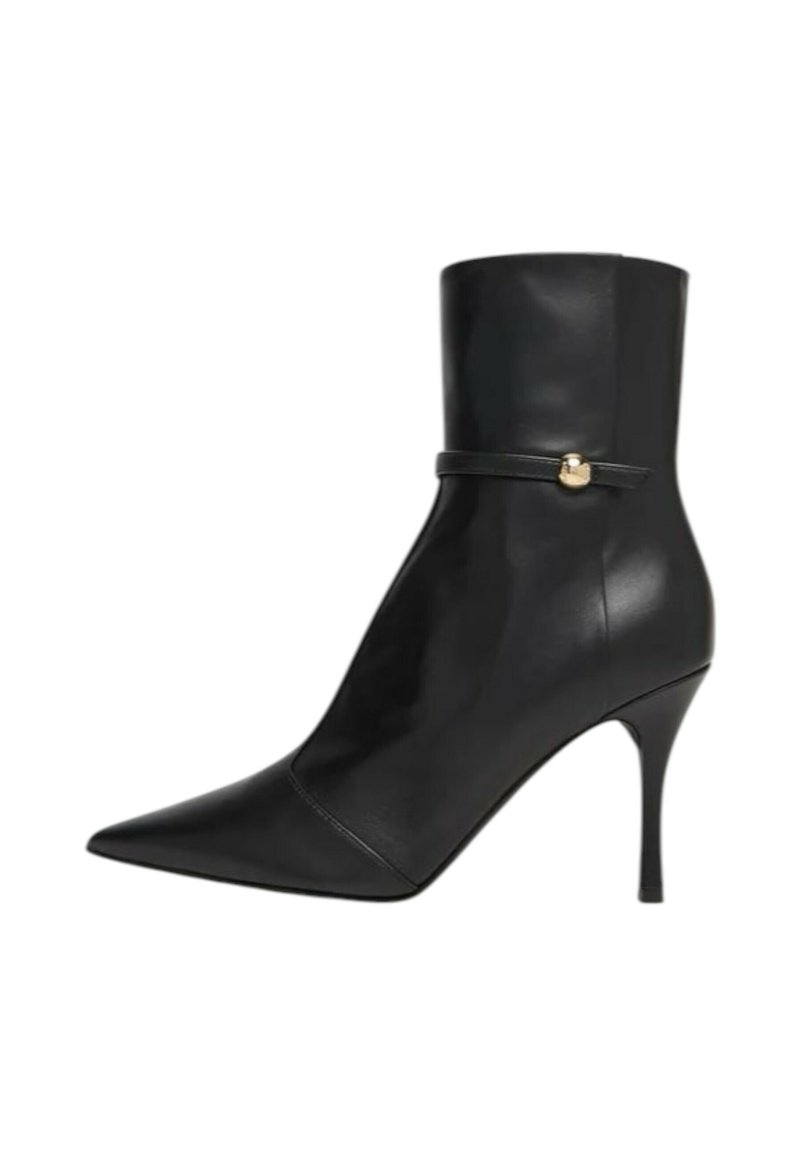 Stivaletto alla caviglia in pelle nera con punta appuntita, tacco a stiletto sottile e una cinghia stretta con dettaglio dorato intorno alla caviglia.