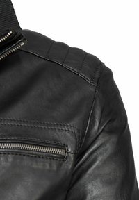 Schwarze Lederjacke mit strukturiertem Oberflächenmaterial, diagonaler Reißverschlusstasche und gepolsterten Schulterakzenten. Glatte Oberfläche mit sichtbaren Nähten.