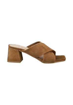 Brauner Veloursleder-Mule mit offener Spitze, gekreuzten Riemen und klobigem mittelhohem Blockabsatz, auf weißem Hintergrund abgebildet.