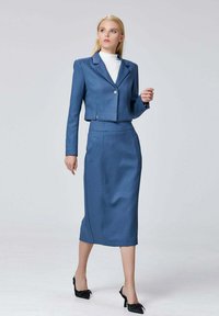 Blazer bleu ajusté avec un bouton unique, associé à une jupe crayon assortie de longueur genou. Tissu lisse, design minimaliste et lignes nettes.