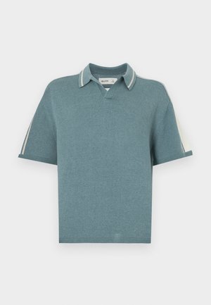Polo-inspirert strikket topp i myk petroleumsfarge, med V-hals, korte ermer og kontrasterende stripete krageakenter. Jevn tekstur gjennom hele.