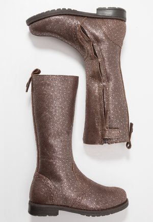 Para wysokich, metalicznie brązowych butów teksturowanych, z bocznymi zamkami błyskawicznymi i pętlami do zakładania, z płaskimi czarnymi gumowymi podeszwami, wyświetlonych na białej powierzchni.