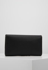 Sac à main rectangulaire noir en cuir texturé, avec une finition lisse et sans matériel ou embellissements visibles.