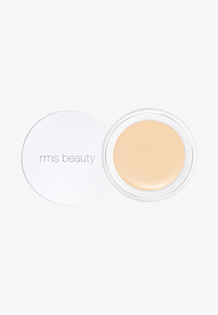 RMS Beauty concealer i en rund vit behållare. Krämig beige produkt synlig inuti. Slät textur, minimalistisk design.