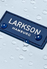 Material impermeabil albastru, cu etichetă de marcă albă reliefată "LARKSON HAMBURG," având picături de apă și o suprafață texturată.