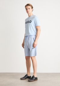 BOSS HEADLO - Spodnji deli trenirk - light blue