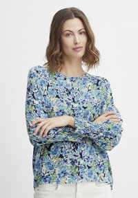 Blumenshirt mit einem blau-grünen Muster. Leichter Stoff, lange Ärmel mit gerafften Bündchen und rundem Halsausschnitt.