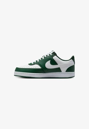 Zapatillas Nike con una parte superior de cuero blanca y verde oscuro, que presentan perforaciones en la puntera y un logo Swoosh blanco.