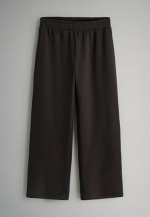 Schwarze Capri-Hosen aus glattem, elastischem Stoff mit einem elastischen Bund, die eine lockere Passform und weite Beine haben, ohne sichtbare Verschlüsse.
