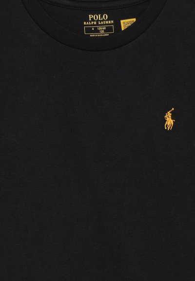 Melns kokvilnas T-krekls ar apaļu kakla izgriezumu un īsām piedurknēm. Satur mazu zeltītu izšūtu logotipu kreisajā krūtī.