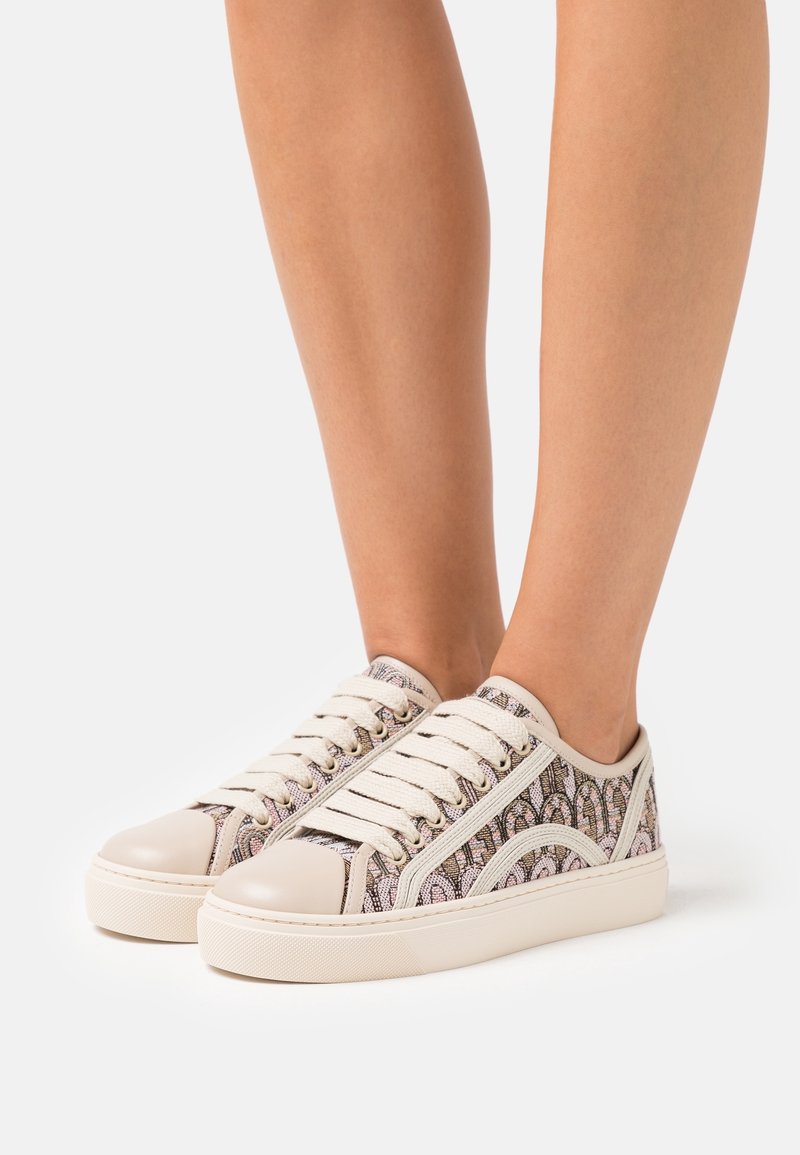 Baskets en toile avec une tige à motifs, des accents crème et un bout rond. Elles comportent des lacets beige et des détails texturés sur le côté.