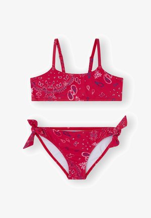 Conjunto de bikini rojo que incluye un bralette con tirantes finos y unas braguitas a juego con un lazo lateral, decorado con patrones de paisley en blanco y azul.
