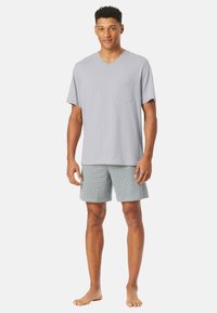Gray v-neck t-shirt with a chest pocket, paired with patterned shorts in blue and white. Soft fabric, relaxed fit, and knee-length design.