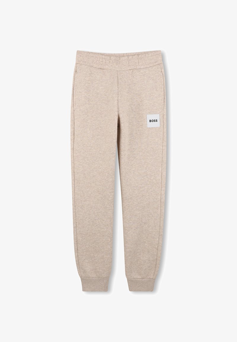 Pantalon de survêtement beige avec ceinture et poignets élastiques, poches latérales, et un patch carré blanc avec le texte "BOSS" sur la partie supérieure de la jambe gauche.