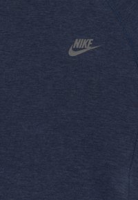 Mörkblå Nike-t-shirt i mjukt tyg, med en liten, ljusgrå Nike-logga på framsidan, rund halsringning och korta ärmar.