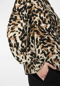 Blouse met panterprint en lange, puffy mouwen in tinten van beige, bruin en zwart; gathered manchetten en een gladde textuur.