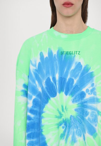 Green tie-dye long-sleeve shirt featuring a blue spiral pattern; the text “STIEGLITZ” is printed subtly on the chest area.