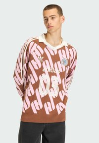 Bruin en roze oversized jersey met patroon en witte accenten, voorzien van een V-hals en het nummer 03. Gemaakt van stof met een getextureerde breiwerk.