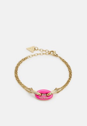 Gold-tone double chain bracelet with a pink oval charm engraved with GUESS and crystal-embellished bar links.