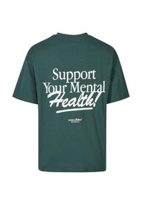 Zaļš kokvilnas T-krekls ar baltu tekstu: "Atbalsti savu garīgo veselību!" un "Vēl viena kokvilna!" logo apakšā. Aprautas apkakles, īsās piedurknes.