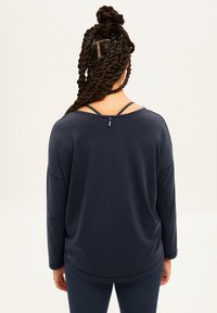 Námořnický dlouhý rukáv s kulatým výstřihem a rozdělenými ramenními popruhy, s volným střihem a hladkou texturou.