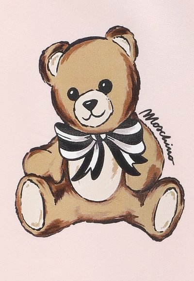 Orsetto di peluche marrone con muso e zampe bianche, che indossa un fiocco a righe bianche e nere, seduto su uno sfondo rosa pallido.