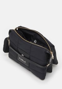 Czarna pikowana torba nylonowa z złotym zamkiem, skórzanym uchwytem i naszywką z logo. Posiada przestronną wnętrze oraz dodatkową przednią kieszeń.