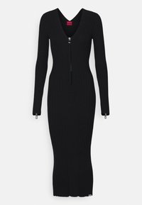 Robe noire côtelée à manches longues avec un col en V et une fermeture éclair à l'avant. Présente une silhouette ajustée et une fente à l'ourlet pour faciliter les mouvements.