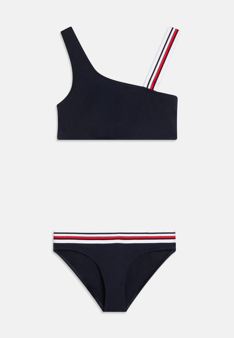 Navy blue bikini set with an asymmetrical top featuring a multi-striped shoulder strap, and bottoms with a matching striped waistband.