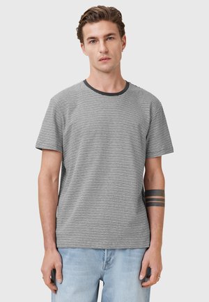 T-shirt a maniche corte a righe in bianco e nero, con scollo tondo e un sottile dettaglio della tasca, realizzato in un tessuto morbido e traspirante.