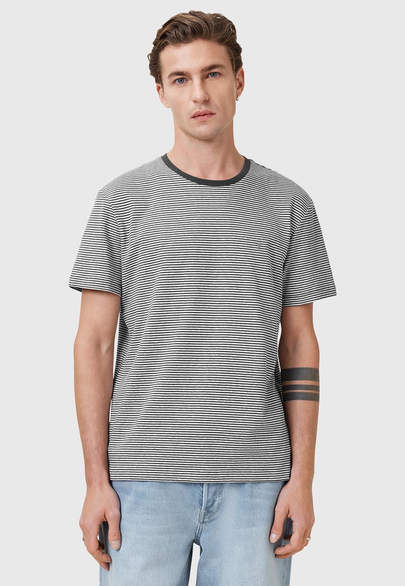 Stribet kortærmet t-shirt i sort og hvid med rund halsudskæring og en subtil lomme detalje, lavet af blødt, åndbart stof.