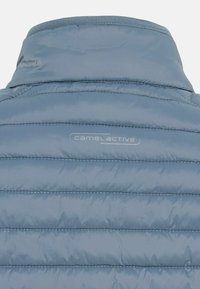 Hellblaues Puffer-Jackett mit horizontalen Nähten, hohem Kragen und einem dezenten „camel active“-Logo auf der Rückseite. Glatte, glänzende Textur.