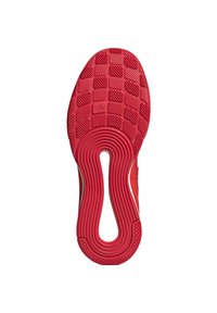 Semelle de sneaker rouge présentant un design texturé et à motifs avec une découpe circulaire. Le matériau semble être en caoutchouc, conçu pour offrir une traction.