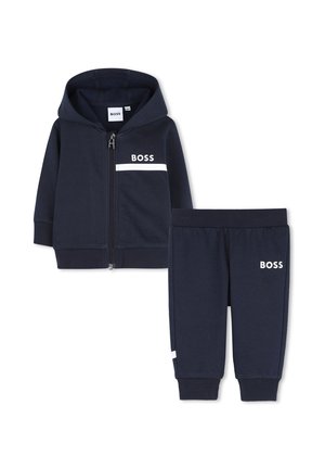 Survêtement bleu marine pour tout-petit avec veste à capuche zippée et pantalon à taille élastique, tous deux présentant des logos "BOSS" blancs et des bandes.
