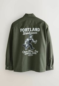 Grünes Arbeitshemd mit einem grafischen Design, das eine Cartoonfigur zeigt, die eine Werkzeugkiste hält, sowie dem Text: "PORTLAND Workwear" und "Geöffnet Mo-Sa ALLGEMEINE WAREN."