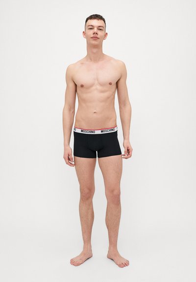 Zwarte boxershorts met een rode en witte Moschino-logo tailleband, aansluitende pasvorm, een gladde textuur en een tailleband met een herhalend merknamen.