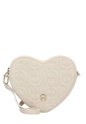 Heart-shaped cream handbag made of textured leather, featuring a quilted design and gold-tone hardware. Adjustable strap included.