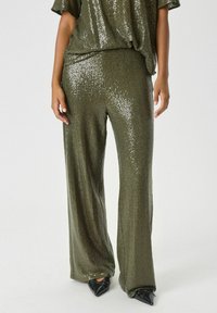 Olijfgroene, met pailletten versierde, wijde broek met een relaxte pasvorm, gecombineerd met een bijpassende top. Glanzende textuur en fonkelende accenten overal.
