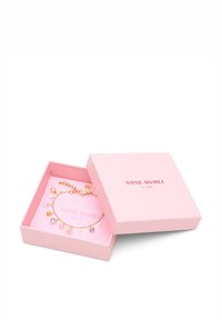 Pulsera de cadena dorada con colgantes de gotas de colores, presentada en una caja rosa clara con interior suave y texto de marca.