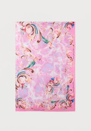 Pink fabric with ornate swirling floral patterns in blue, green, and gold tones, featuring a signed border detail on pale to bright pink background.
