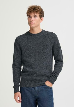 Dunkelgrauer, gestrickter Pullover mit Rundhalsausschnitt, gerippten Bündchen und Saum. Getragen mit blauen Jeans. Die Textur wirkt weich und warm.
