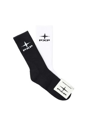 Una coppia di calzini crew neri e una bianchi, ciascuno con un logo "PXP" bianco e nero e un disegno a stella vicino alla parte superiore.