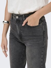 Šedé džíny z denimu s přiléhavým střihem, vybavené předním zapínáním na knoflík, pěti kapsami a minimálním opotřebením. Hladká textura s jemným leskem.