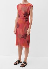 Vestido rojo con estampado, con cintura anudada, mangas cortas y corte a media pierna. La tela presenta una textura sutil con estampados botánicos.