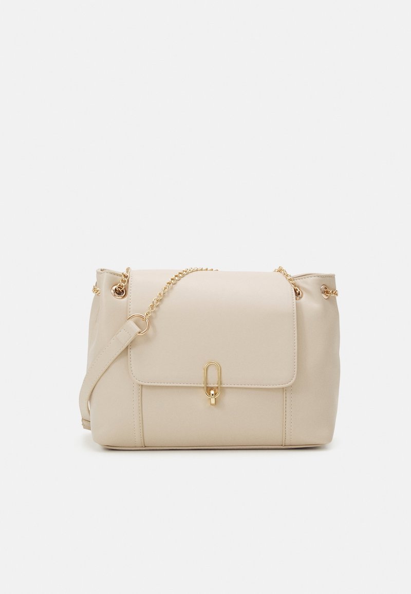 Beige Lederhandtasche mit Klappe vorne, goldfarbenen Beschlägen und abnehmbarem Kettenriemen. Glatte Textur und minimalistisches Design.