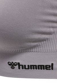Grijze gebreide stof met zwart geborduurd hummel-logo en gestileerde bij aan de onderkant.