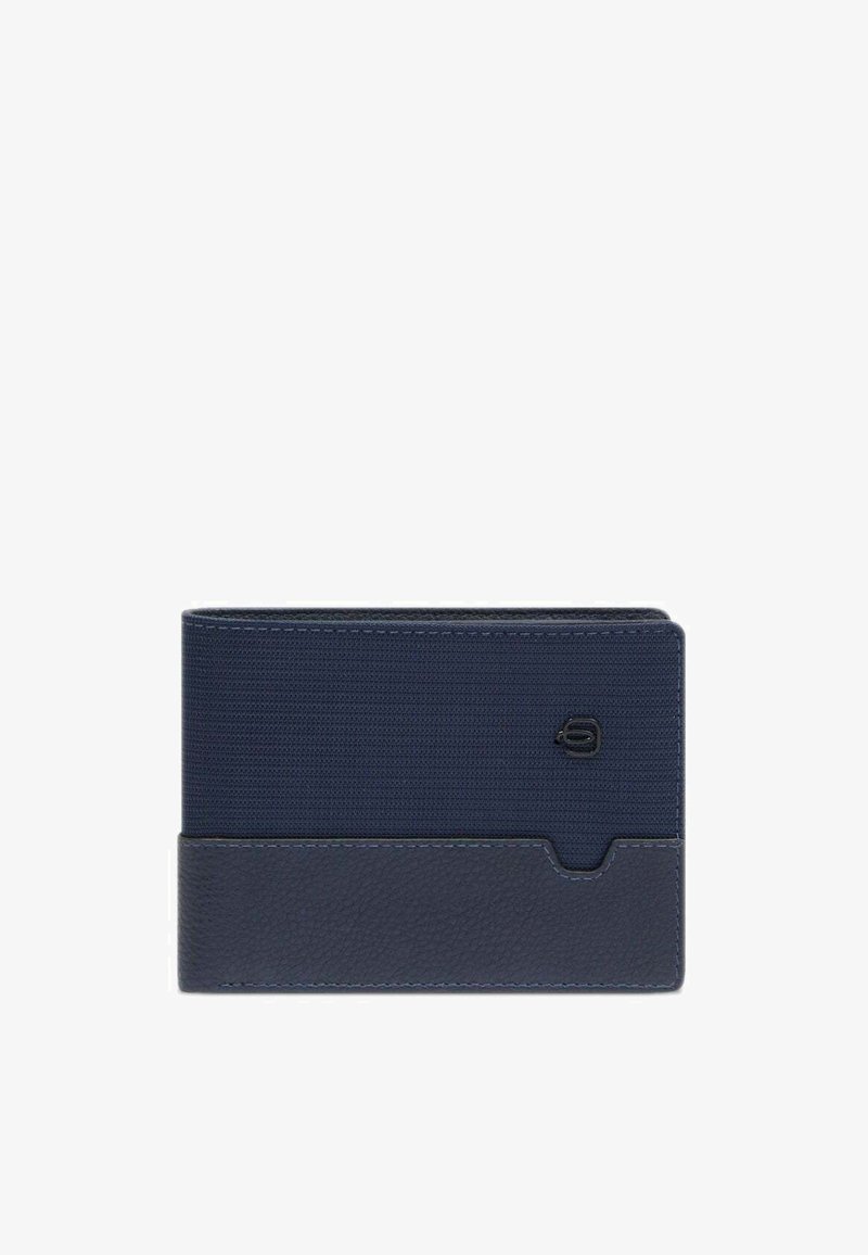 Cartera de navy con parte superior de nailon texturizado y parte inferior de cuero liso. Presenta un corte lateral y un discreto detalle del logo. Forma rectangular.